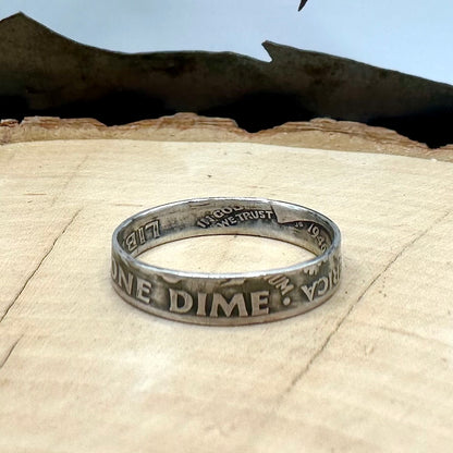 U.S. Dime Coin Ring on a light wood round with a metal mountain background. - Mountainstruck Coin Jewelry