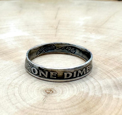 U.S. Dime Silver Coin Ring patina on a light wood round with a metal mountain background. - Mountainstruck Coin Jewelry