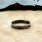 U.S. Dime Silver Coin Ring patina on a light wood round with a metal mountain background. - Mountainstruck Coin Jewelry