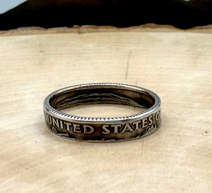 U.S. Dime Silver Coin Ring patina on a light wood round with a metal mountain background. - Mountainstruck Coin Jewelry