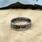 U.S. Standing Liberty Quarter Silver Coin Ring ion a light wood round with a metal mountain background. - Mountainstruck Coin Jewelry