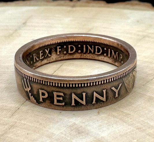 UK One Penny Coin Ring on a light wood round with metal mountain background. - Mountainstruck Coin Jewelry