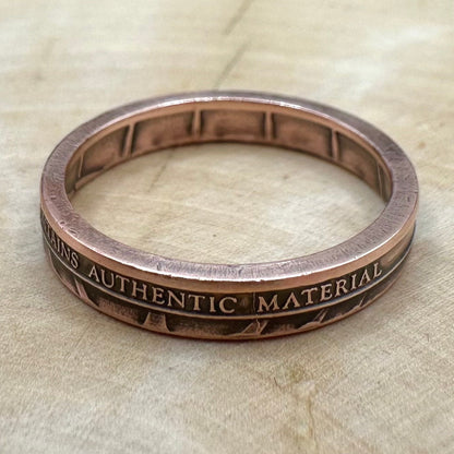U.S. Authentic Copper Statue of Liberty Token Ring on a light wood background. - Mountainstruck Coin Jewelry