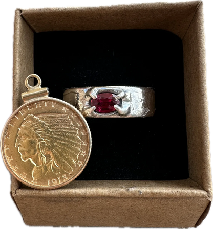 Gold coin with Indian head design and silver ring with red ruby in a brown kraft box on a black velvet background. - Mountainstruck Coin Jewelry