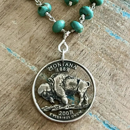 Necklace with turquoise beads and a Montana Quarter/Buffalo Nickel pendant on a wooden surface. - Mountainstruck Coin Jewelry