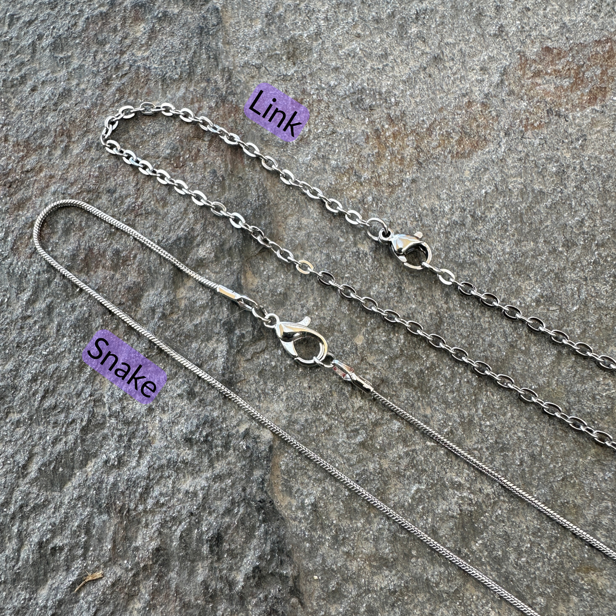 Link chain and snake chains set on a gray stone surface with black text and light purple background for each type of chain. 
- Mountainstruck Coin Jewelry
