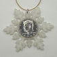 2025 Half Dollar Christmas Ornament (glows) with an uncirculated half dollar cased inside a white 3D printed snowflake with golden tassel on a white background. - Mountainstruck Coin Jewelry