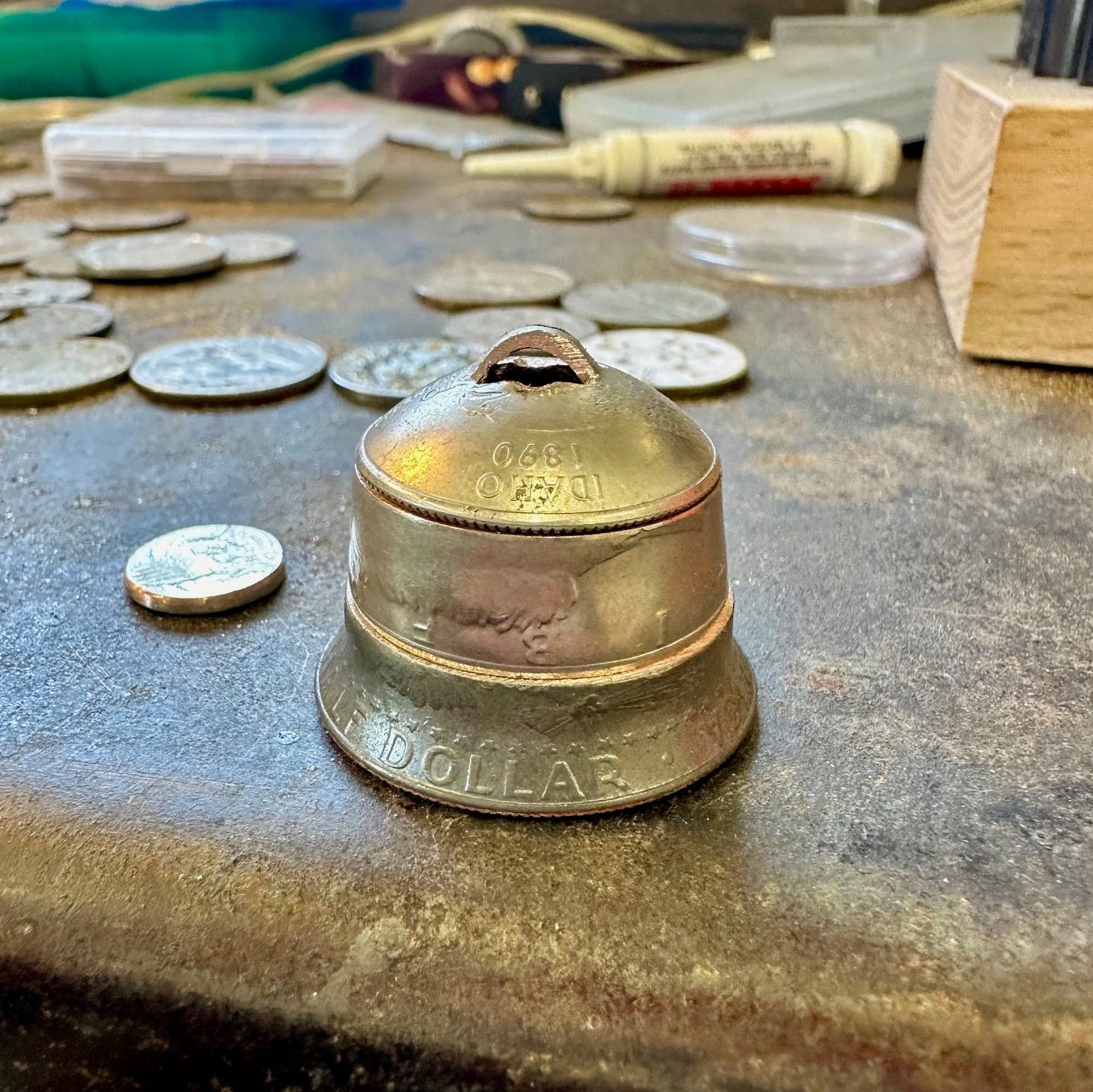 2025 Holiday Coin Bell Ornament on a metal bench top. - Mountainstruck Coin Jewelry