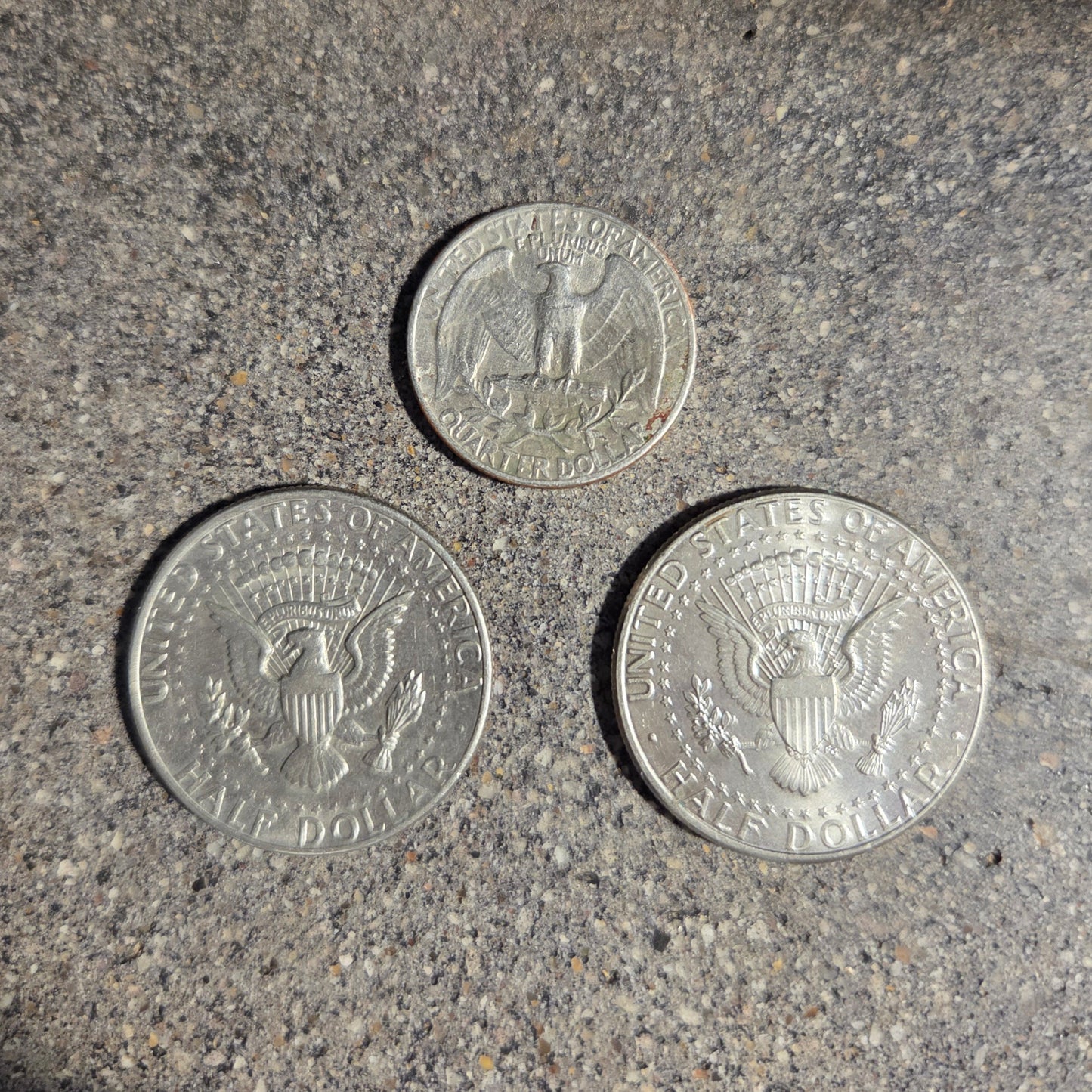 U.S. Quarter and Two Half Dollar Coin backs on a concrete surface used in the 2025 Holiday Coin Bell Ornament. - Mountainstruck Coin Jewelry