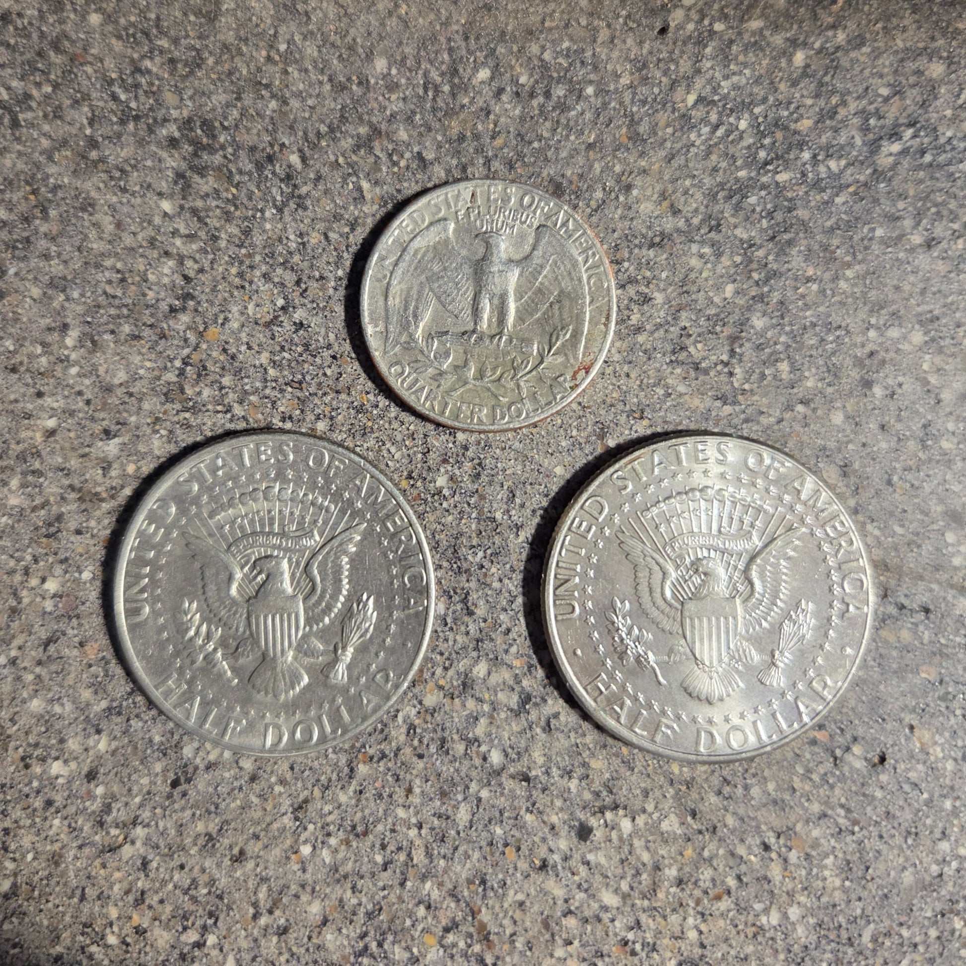 U.S. Quarter and Two Half Dollar Coin backs on a concrete surface used in the 2025 Holiday Coin Bell Ornament. - Mountainstruck Coin Jewelry