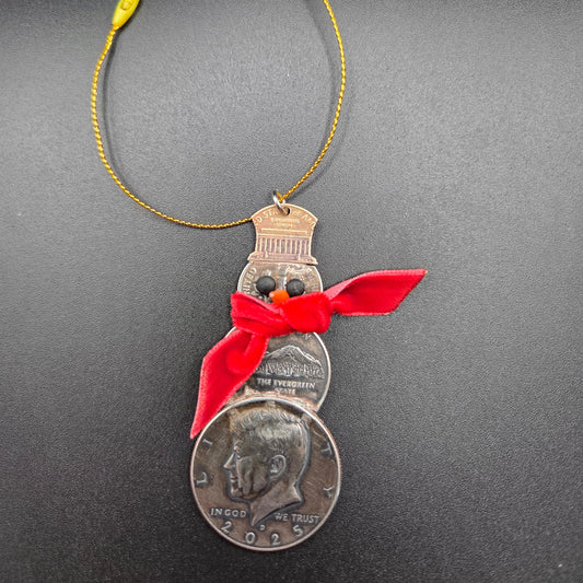 2025 Snowman Coin Christmas Ornament with a selection of U.S. coins (penny, dime, state quarter, and 2025 uncirculated half dollar) soldered into a snowman with a red ribbon scarf and golden tassel on a black background. - Mountainstruck Coin Jewelry