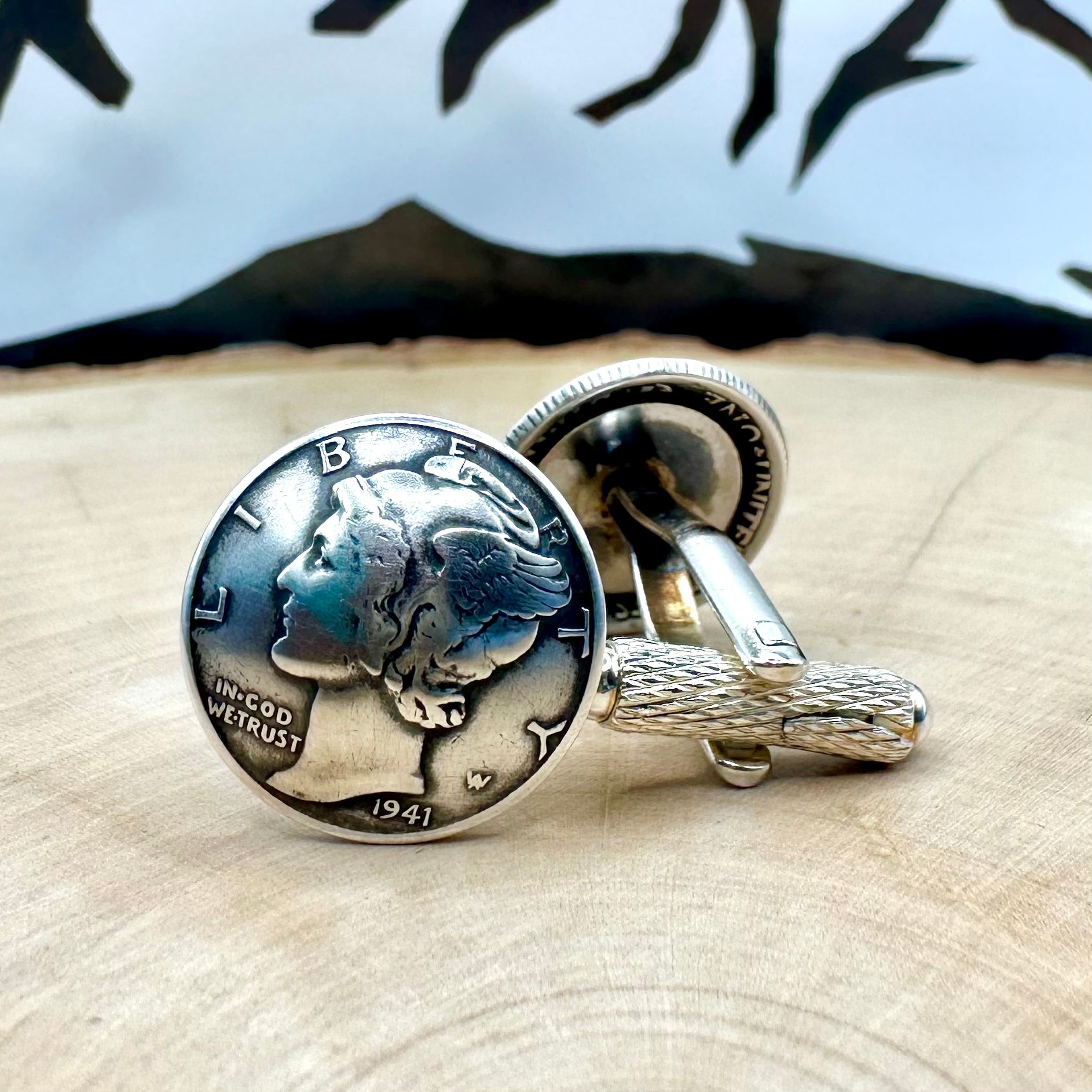 U.S. Silver Mercury Dime Domed Coin Cufflinks on a light wood round with a metal mountain background.- Mountainstruck Coin Jewelry