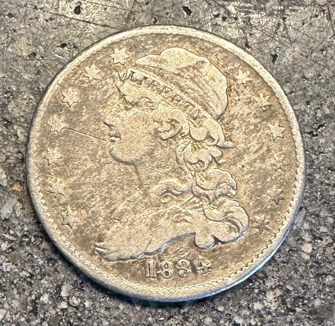 Capped Bust Liberty Quarter Silver Coin front on a concrete surface. - Mountainstruck Coin Jewelry