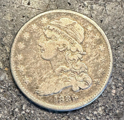 Capped Bust Liberty Quarter Silver Coin front on a concrete surface. - Mountainstruck Coin Jewelry