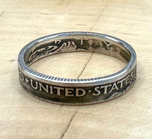 U.S. Mercury Dime Silver Coin Ring on a light wood round with metal mountains in the background. - Mountainstruck Coin Jewelry