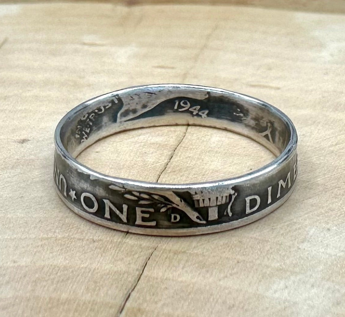 U.S. Mercury Dime Silver Coin Ring on a light wood round with metal mountains in the background. - Mountainstruck Coin Jewelry