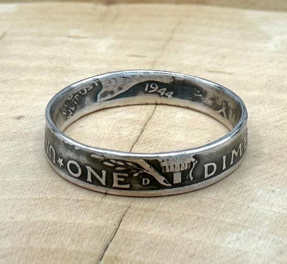 U.S. Mercury Dime Silver Coin Ring on a light wood round with metal mountains in the background. - Mountainstruck Coin Jewelry