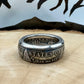 Morgan Dollar Silver Coin Ring patina on a light wood round with a metal mountain background. - Mountainstruck Coin Jewelry