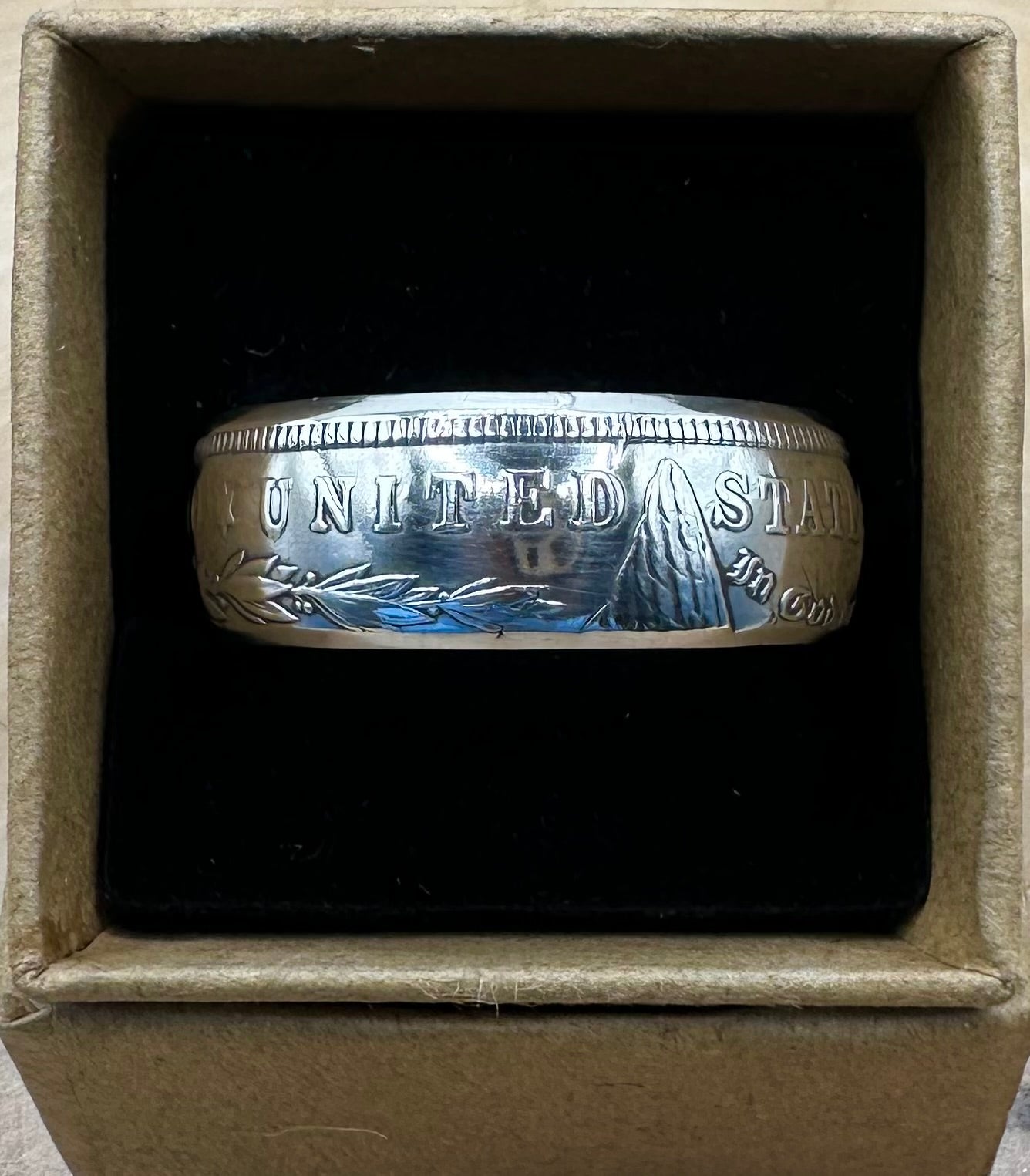 Morgan Dollar Silver Coin Ring shine in a brown kraft box on a black velvet background. - Mountainstruck Coin Jewelry