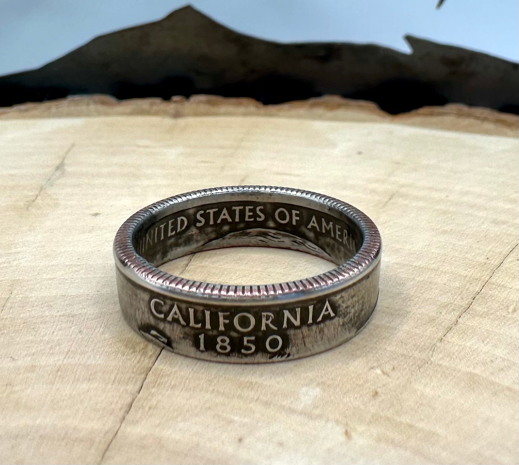 U.S. State Quarter Coin Ring featuring California on a light wood round with metal mountain background. - Mountainstruck Coin Jewelry