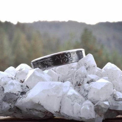 U.S. State Quarter Coin Ring on a with geode in front of a blurred pine tree mountainous sky. - Mountainstruck Coin Jewelry