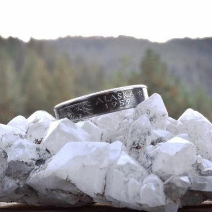 U.S. State Quarter Coin Ring on a with geode in front of a blurred pine tree mountainous sky. - Mountainstruck Coin Jewelry