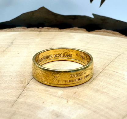 Gold Plated U.S. State Quarter Coin Ring featuring Idaho on a light wood round with metal mountain background. - Mountainstruck Coin Jewelry