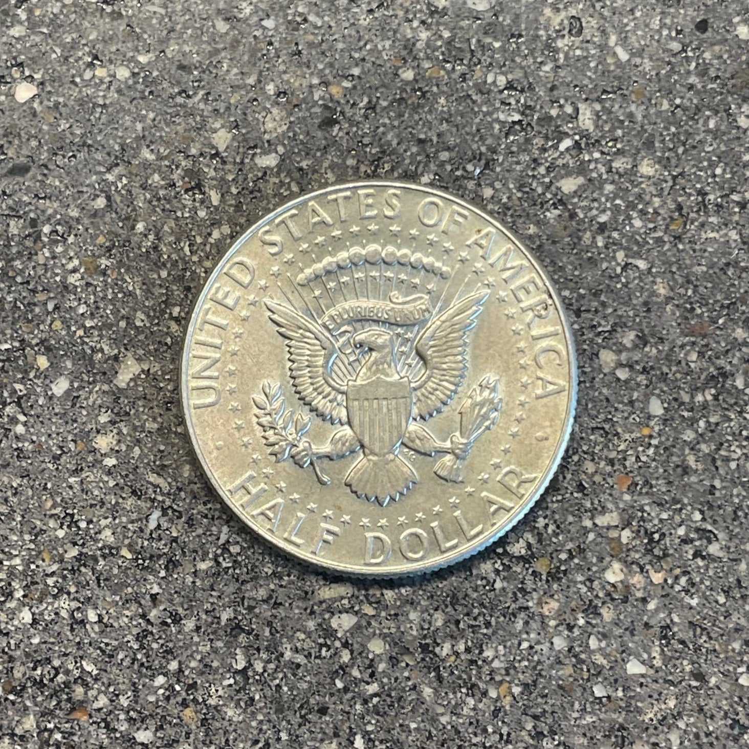 U.S. JFK Silver Half Dollar Coin back on a concrete background. - Mountainstruck Coin Jewelry