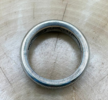 U.S. Morgan Dollar Silver Coin Ring ridged edge facing up on a light wood background. - Mountainstruck Coin Jewelry