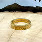 "V" Nickel Coin Ring 24k gold plated on a light wood round with a metal mountain background. - Mountainstruck Coin Jewelry