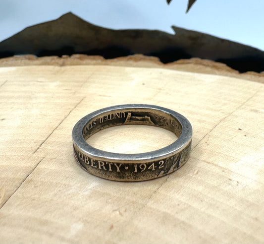 WW2 Nickel Silver Coin Ring on a light wood round with a metal mountain background. - Mountainstruck Coin Jewelry