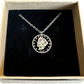 U.S. "V" Nickel Hand Cut Coin Necklace with a stainless chain in a brown kraft box with a black velvet background.