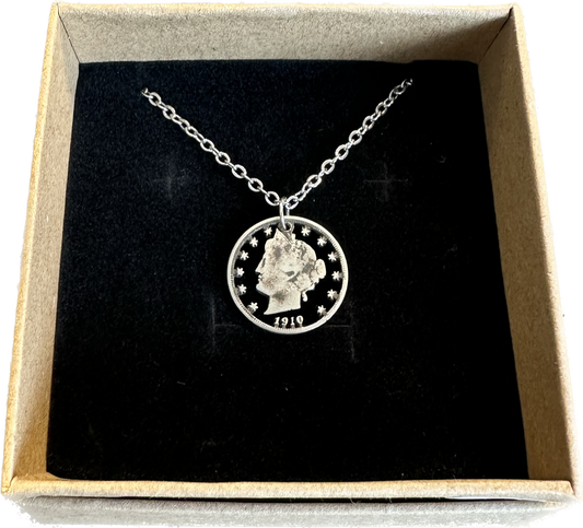 U.S. "V" Nickel Hand Cut Coin Necklace with a stainless chain in a brown kraft box with a black velvet background.