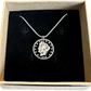 U.S. "V" Nickel Hand Cut Coin Necklace with a snake chain in a brown kraft box with a black velvet background.