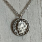U.S. "V" Nickel Hand Cut Coin Necklace with a stainless chain on a white wood background.