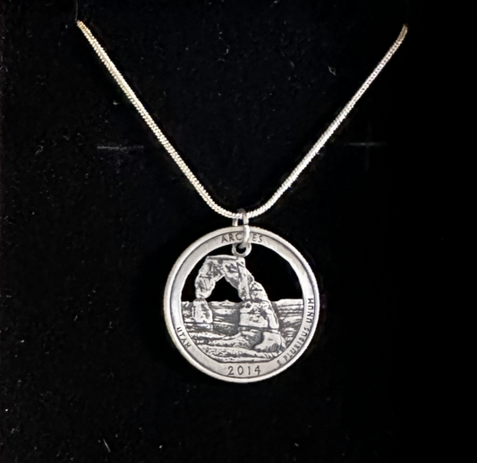 U.S. Arches National Park Coin Necklace on a black velvet background.
