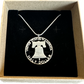 Cracked Liberty Bell U.S. Half Dollar Hand Cut Coin Necklace with a snake chain in a brown kraft box on a black velvet background.