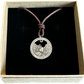 Idaho "River of No Return" Hand Cut Quarter Necklace with a leather cord in a brown kraft box on a black velvet background.