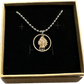 U.S. Indian Head Penny Coin Necklace with a steel ball chain in a brown kraft box on a black velvet background.