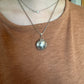 U.S. Silver Quarter Hand Crafted Coin Locket Necklace on a person with a tan/orange shirt.