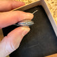 U.S. Silver Quarter Hand Crafted Coin Locket Necklace showing the magnetic closure in a brown kraft box on a black velvet background.