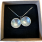 U.S. Silver Quarter Hand Crafted Coin Locket Necklace open in a brown kraft box on a black velvet background.