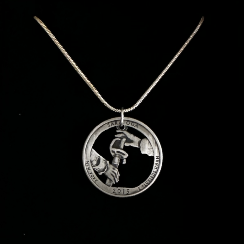 U.S. Saratoga British Surrender Hand Cut Coin Necklace on black velvet background.