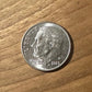 Dime Coin front on a wood background.