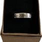 "V" Nickel Coin Ring in brown kraft box with black velvet background.