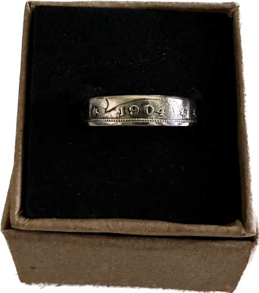 "V" Nickel Coin Ring in brown kraft box with black velvet background.