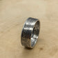 Newfoundland 50 Cents Silver Coin Ring on its edge on a light wood round.