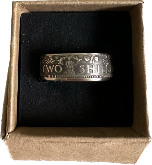 UK Two Shillings Coin Ring in a brown kraft box on a black velvet background.