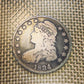 (Rare) Capped Bust Liberty Silver Half Dollar front of coin on woven background.