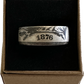 Seated Liberty Silver Half Dollar Coin Ring (reverse patina) in a brown kraft box on a black velvet background.